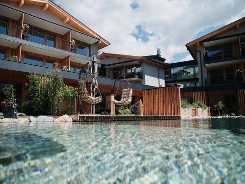 Bazén v ubytování Wellness und Brunch Hotel MorgenZeit beheizter Naturpool mit Sandstrand Genuss Frühstück bis 13 Uhr Hochkönig Sommercard nebo v jeho okolí