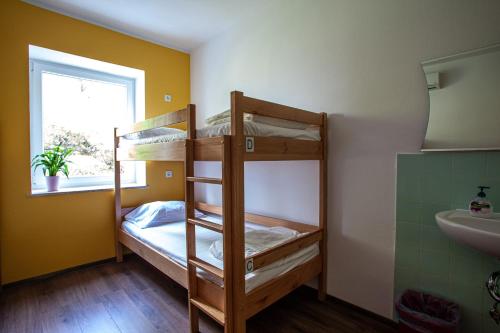 two bunk beds in a room with a sink and a window at Hostel Trobenta in Oblak in Portorož