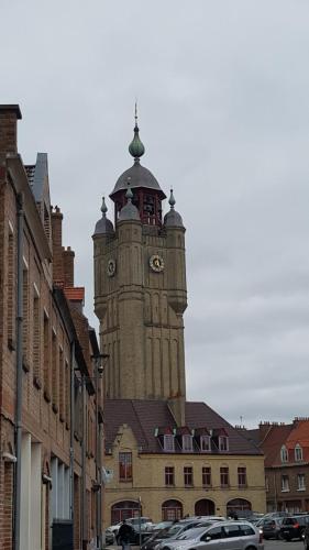 a tall tower with a clock on top of a building at chambres d'hôtes Le Carillon in Bergues