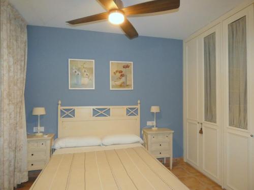 1 dormitorio con 1 cama y ventilador de techo en Rentalmar Verdi Adosados, en Miami Platja