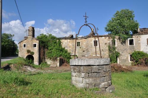 an old building with a stone wall in front of it at KIŽIN House, Cozy apartments by Istrian Embrace in Brezovica pri Gradinu