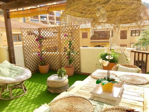 een patio met een tafel en stoelen en potplanten bij Ático en Playa Altea - Puerto de Campomanes in Altea