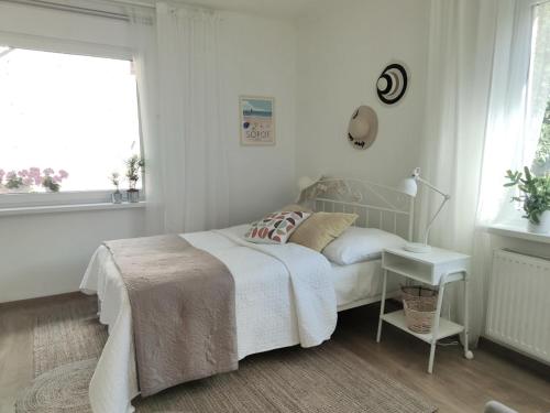 a bedroom with a bed and a table and a window at Apartament w sąsiedztwie lasu 1800m od morza in Sopot