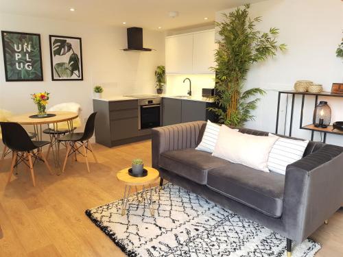 a living room with a couch and a kitchen at Woodcock Farm Holidays in Glossop
