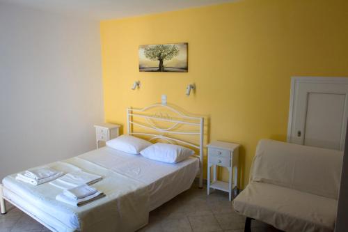 a yellow bedroom with a bed and a couch at Villa Molos in Limenas