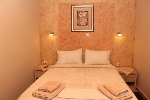 a bedroom with a bed with two towels on it at Germanos Studios in Kato Loutraki
