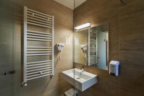 ein Bad mit einem Waschbecken und einem Spiegel in der Unterkunft Eden 5 in Predeal