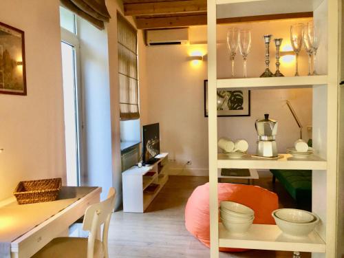 una habitación con una mesa y un estante con platos en The White Loft, en Tiflis