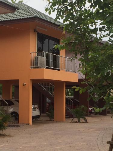 a building with a balcony on the side of it at Lampang Ngeng Na Home in Lampang