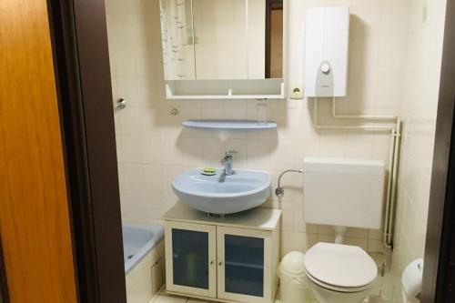 a bathroom with a sink and a toilet and a mirror at Biete ruhige Zwei-Zimmer Souterrain-Wohnung in Niederkassel