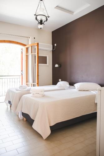 a bedroom with two beds and a large window at Sisiotisa in Argostoli
