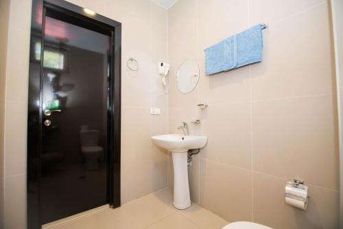 a bathroom with a white sink and a toilet at Ef Palace Shekvetili in Shekhvetili