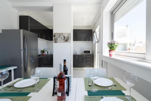 a kitchen with a table and chairs and a refrigerator at Moreira 284 in Porto
