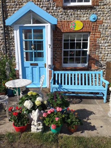 a blue door and a bench in front of a building at Glory Days in Cromer