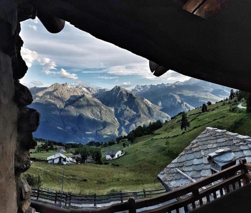 a view of a mountain range from a window at Baita di charme con vista meravigliosa in Verrayes