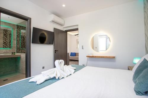 a bedroom with a white bed with a towel on it at Platoni Elite in Ialyssos