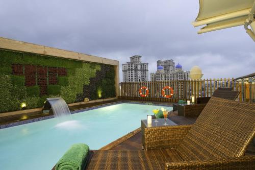 a swimming pool with two chairs and a fence at Meluha - The Fern in Mumbai