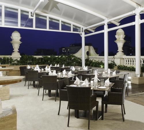 a restaurant with tables and chairs on a patio at night at Meluha - The Fern in Mumbai