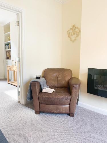 a brown leather chair sitting in a living room at Park Crescent Lodge - Quaint Victorian Home With Free Parking in York