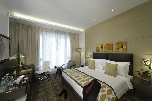 a hotel room with a large bed and a desk at Meluha - The Fern in Mumbai
