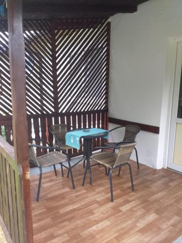 a table and chairs in a room with a wooden wall at Vikendica Iva in Perućac