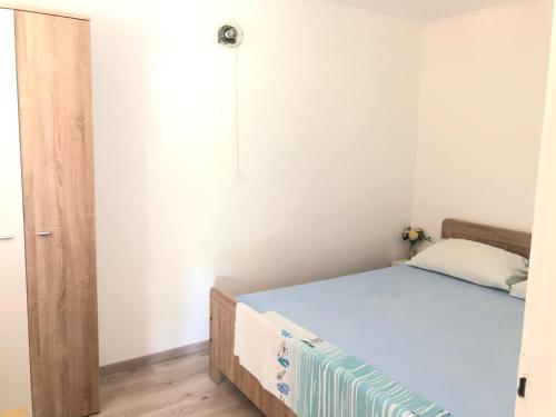 a small bedroom with a bed and a mirror at Little house Ljubica in Kampor