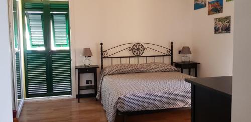 a bedroom with a bed and two tables and two windows at CASA ELA in Levanto