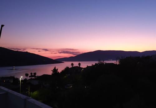 a sunset over a body of water with mountains at Hotel Olimpija plus in Herceg-Novi