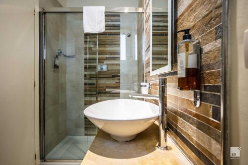 a bathroom with a white sink and a shower at Hotel Regina Elena 57 & Oro Bianco SPA in Rimini