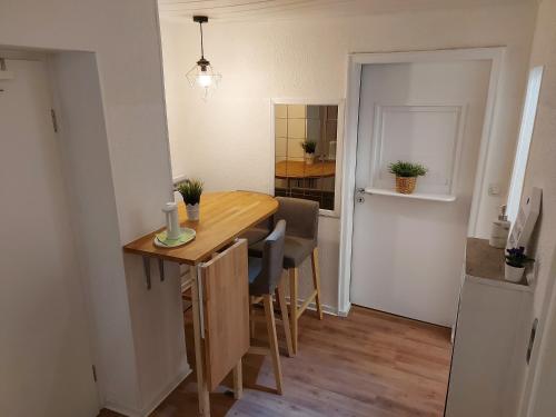 uma cozinha e sala de jantar com uma mesa de madeira e cadeiras em Overnight Apartment em Colônia