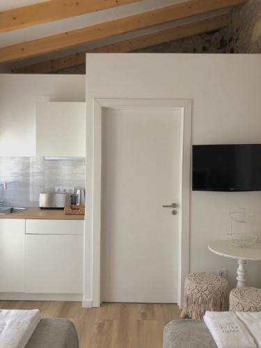 a kitchen with white cabinets and a door with a table at Douro Pateo House in Vila Nova de Gaia