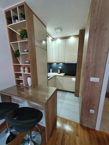 cocina con escritorio y sillas en una habitación en Apartman Lux Doboj 2, en Doboj