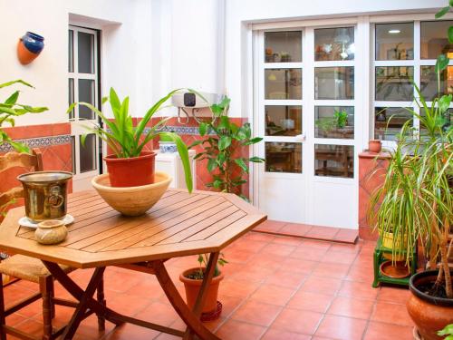 un patio con macetas y una mesa de madera. en Belvilla by OYO Preciosa casa en Sevilla, en Sevilla