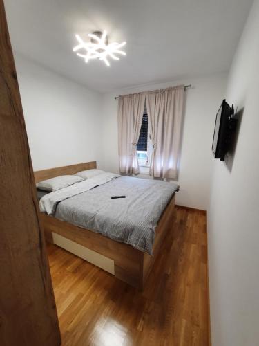 1 dormitorio con cama y lámpara de araña en Apartman Lux Doboj 2, en Doboj