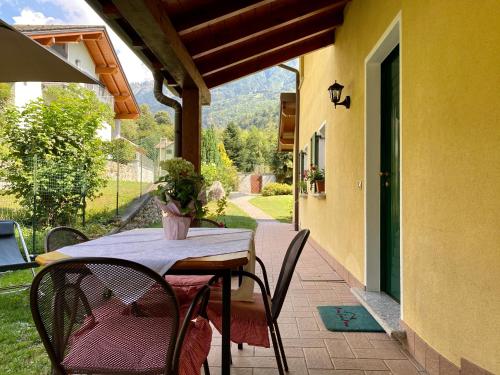 una mesa y sillas en el porche de una casa en La Rosa Home, en Piuro