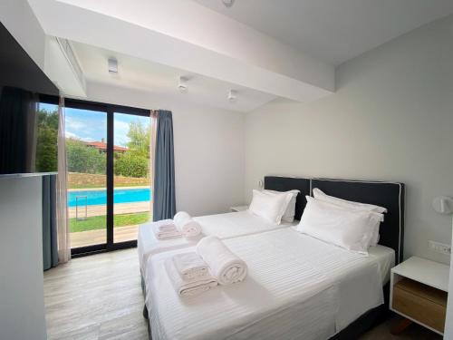 a bedroom with a bed with white sheets and towels at EOS Luxury Suites in Kriopigi