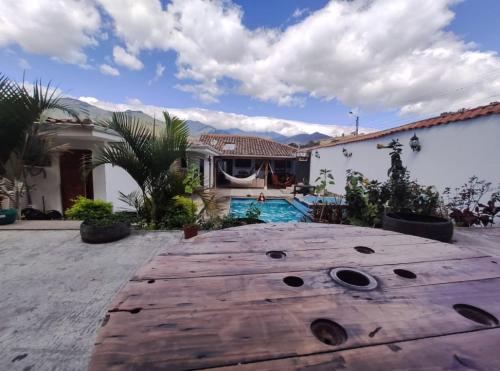 a backyard with a wooden table and a swimming pool at Hostel las Palmas in Vilcabamba