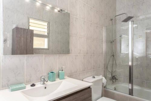 Un baño con lavabo, inodoro y ducha. en Casa Yamile, en Tarajalejo