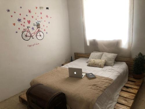 a bedroom with a bed with a laptop on it at Hostel las Palmas in Vilcabamba