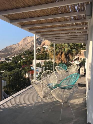 a group of chairs and tables on a balcony at Calma apartment in Masouri