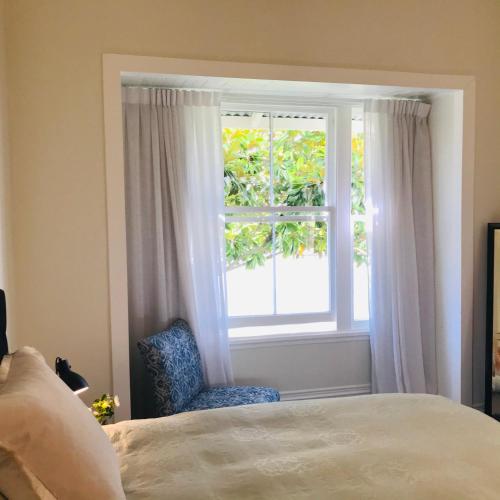 a bedroom with a bed and a window at Bryce Cottage in Cambridge