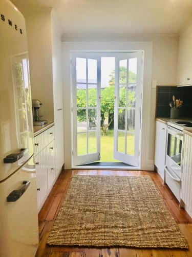 a kitchen with an open door to a yard at Bryce Cottage in Cambridge