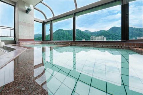 een zwembad met uitzicht op de bergen bij MolinHotels501 -Sapporo Onsen Story- 1L2Room W-Bed4&S-6 10persons in Sapporo