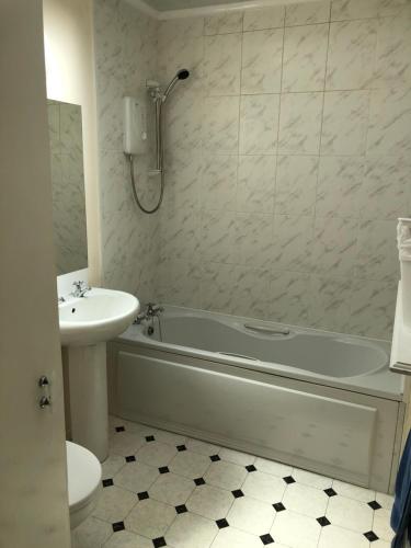 y baño con bañera, lavabo y aseo. en Spacious home by the sea in Scalloway. en Scalloway