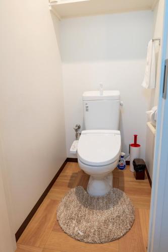 a bathroom with a toilet with a rug on the floor at Nishihan in Kyoto