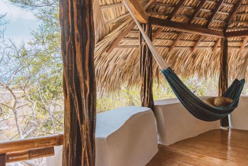 a hammock in a room with a large window at New Ruins Off-The-Grid SuperAdobe Domes with Pool in San Francisco de Abajo