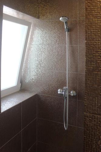 a shower in a bathroom with a window at Casinha da Andorinha - Ericeira in Ericeira