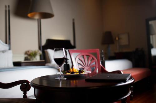 a glass of wine on a table in a hotel room at Casa Grande Hotel Boutique in Morelia
