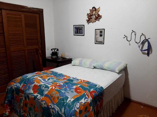 een slaapkamer met een bed met een kleurrijke deken erop bij Casa no Centro Histórico de Pirenópolis in Pirenópolis