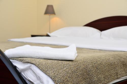 two beds with white towels sitting on the bed at Pension Yasmine in Timişoara